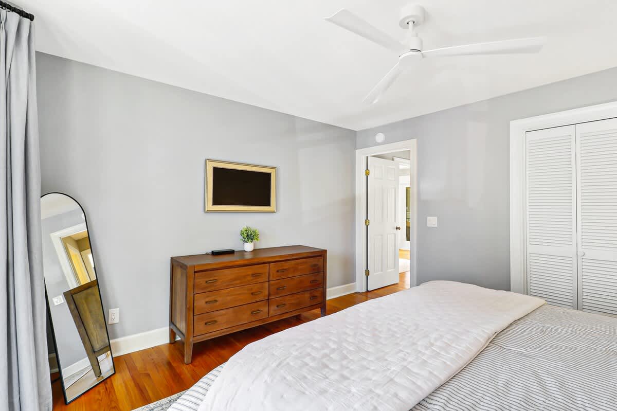 Your peaceful bedroom features warm hardwood floors, elegant furniture, and a ceiling fan to keep you comfortable throughout your stay.