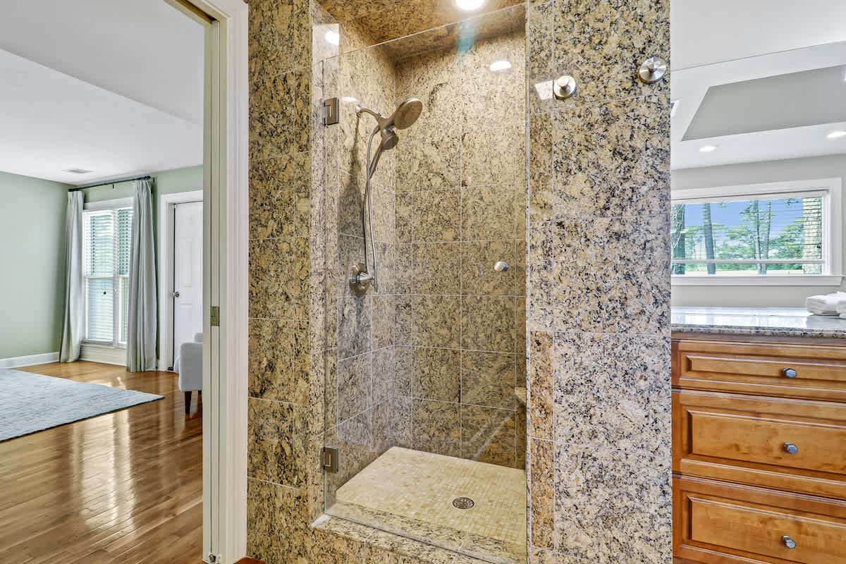 Step into your spa-like granite shower with rainfall head, where polished stone surrounds create a luxurious daily escape.