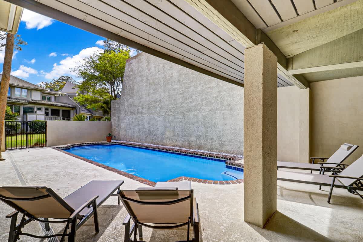 Your private pool oasis awaits beneath a covered patio, perfect for cooling off or lounging poolside in complete privacy.