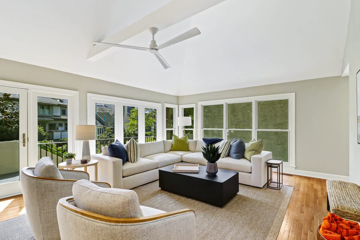 Relax in your bright living room with plush seating, soaring ceilings, and garden views through floor-to-ceiling windows.