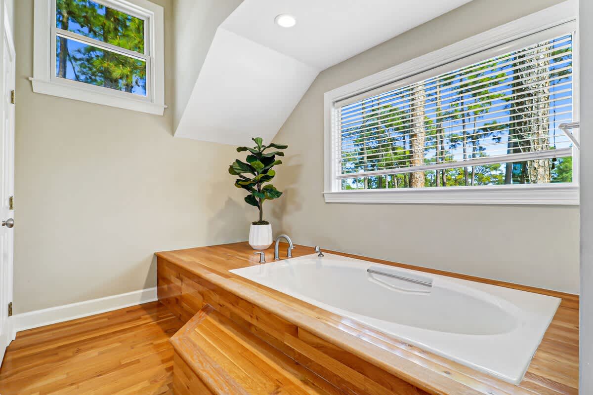 Sink into this luxurious soaking tub surrounded by warm wood accents and natural light streaming through your private windows.