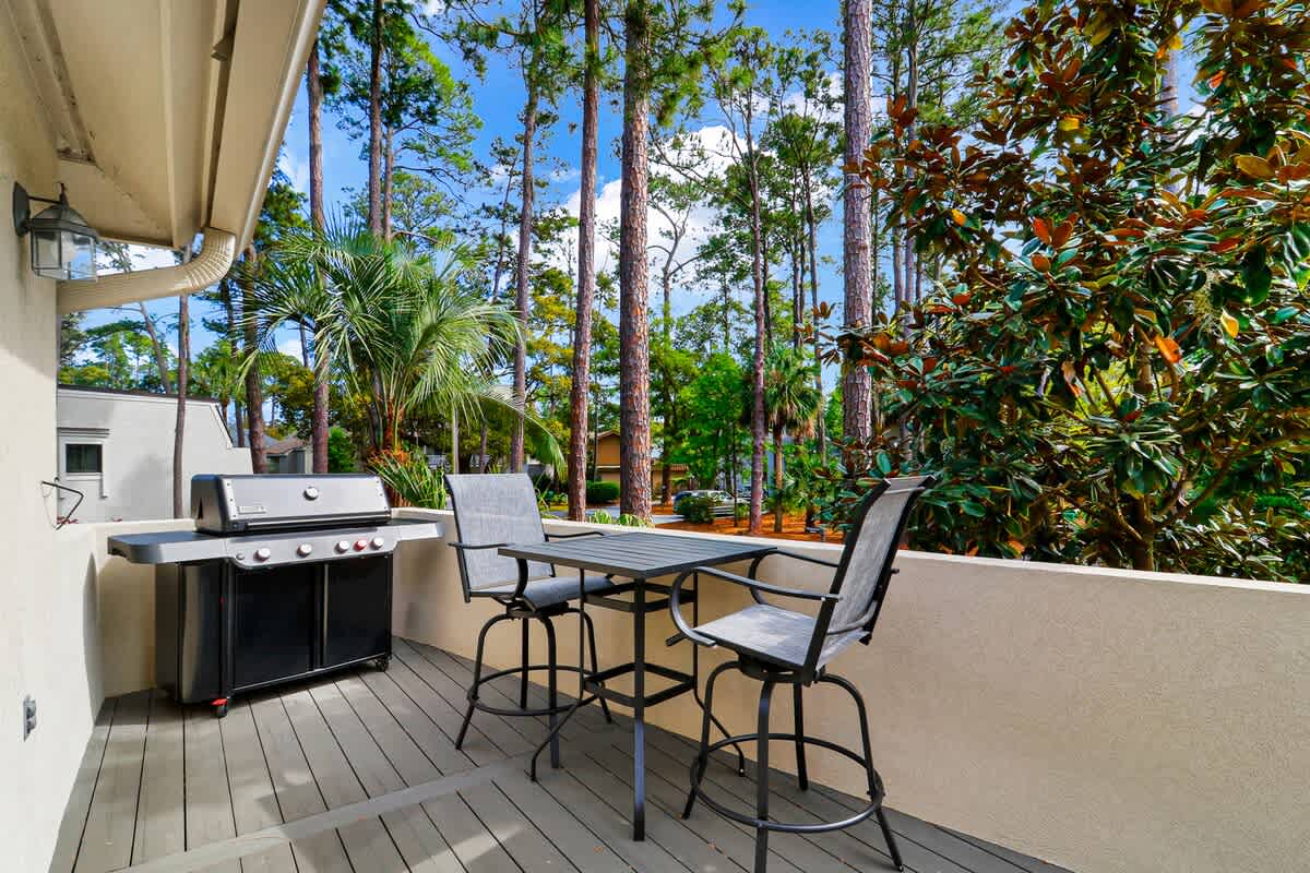 Fire up the grill on your private patio surrounded by tropical palms and towering pines—your perfect outdoor dining escape awaits.