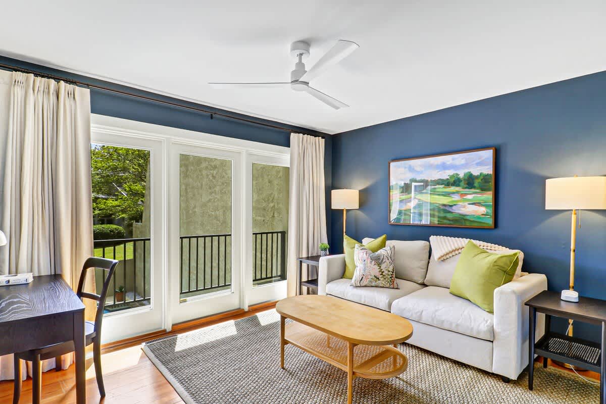 Unwind in your stylish living room with plush seating, natural light streaming through French doors, and a peaceful balcony view.