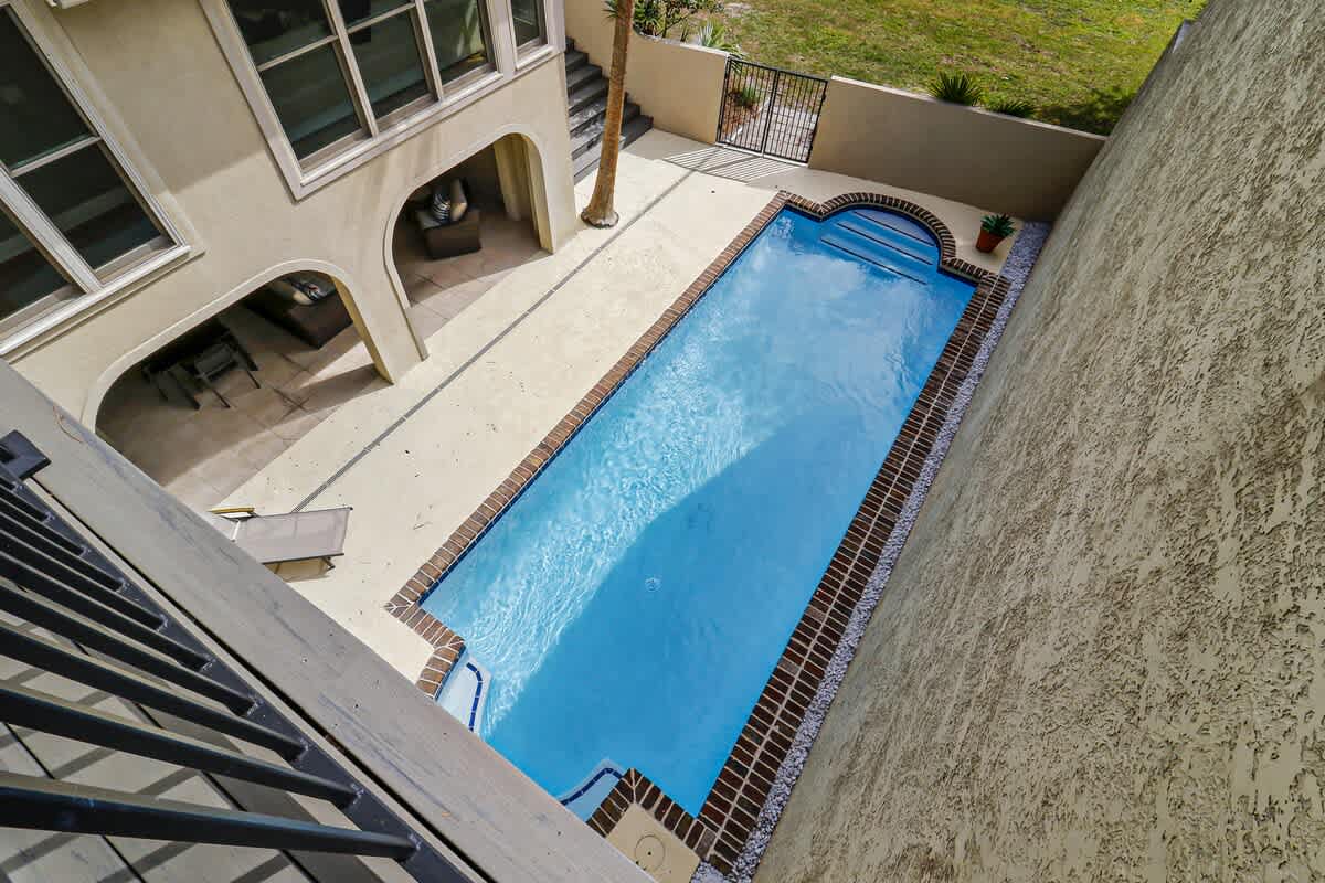 Aerial view of the property showing the private swimming pool and outdoor entertainment areas with covered seating spaces.