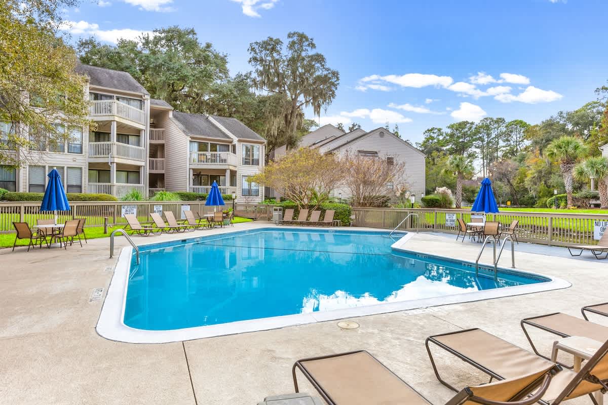 Take a refreshing dip in the sparkling pool, then relax on comfortable loungers under cheerful blue umbrellas in this peaceful community setting.