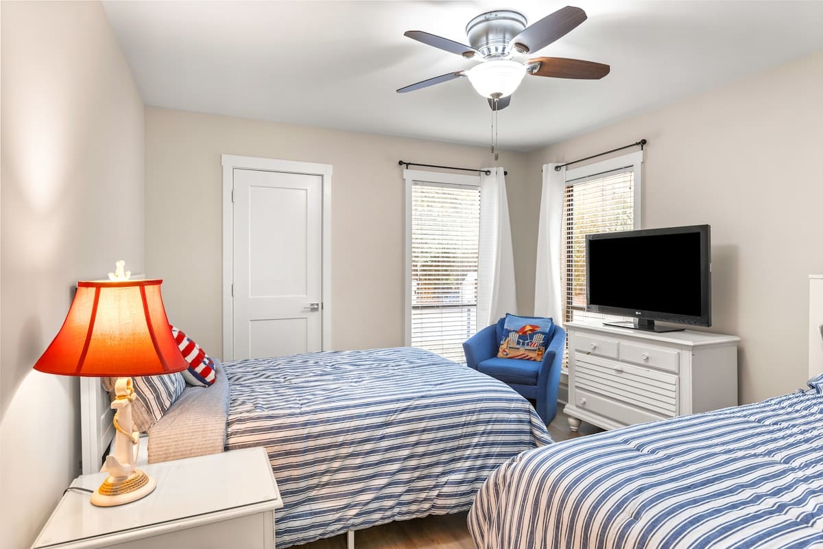 Drift off in this cozy bedroom with comfortable double beds, ceiling fan, and cheerful nautical touches that make you feel right at home.