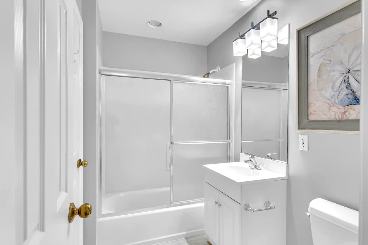 Step into your elegant bathroom featuring a glass-enclosed shower-tub combo, contemporary lighting, and spa-like touches for your daily retreat.