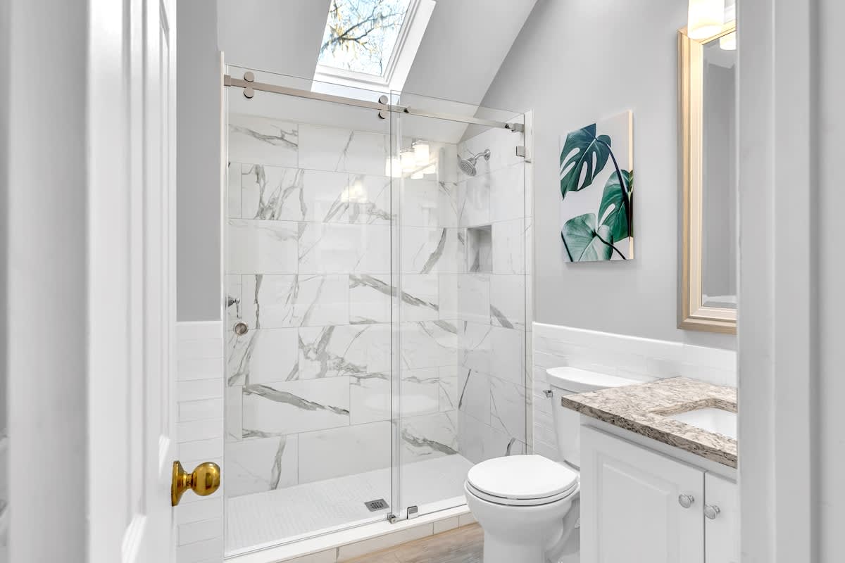 Step into your spa-like bathroom with stunning marble shower, skylight views, and elegant finishes for ultimate relaxation.