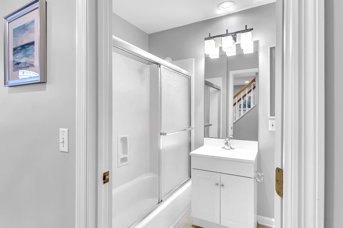 Step into your pristine bathroom with gleaming fixtures, modern vanity, and spacious shower-tub combo perfect for unwinding after exploring.