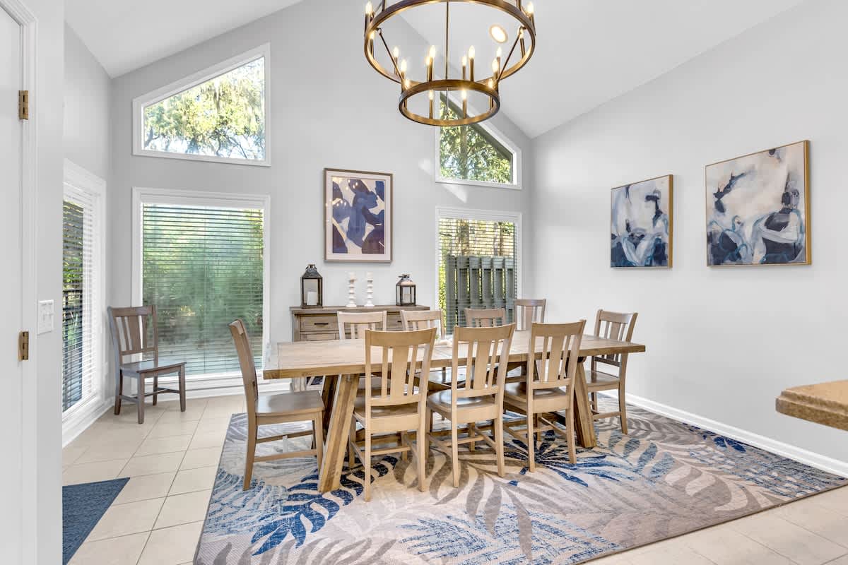 Gather around this elegant dining table where natural light streams through tall windows, creating the perfect setting for memorable meals together.
