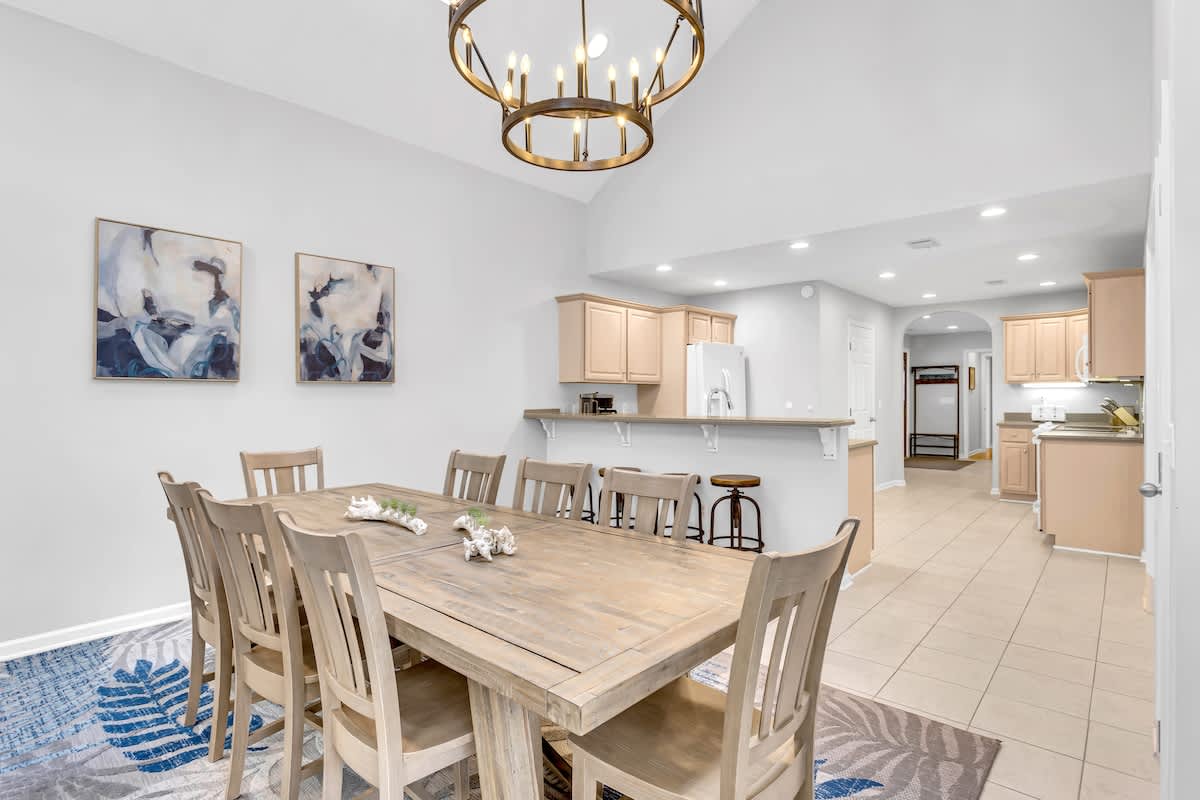Gather around your spacious dining table where golden light and open kitchen flow create the perfect setting for memorable meals together.