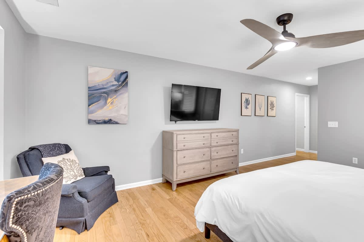 Your serene bedroom features a cozy reading chair, flat-screen TV, and ample storage in this thoughtfully appointed space.