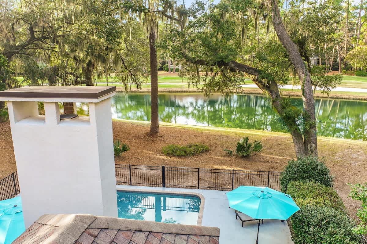 Stunning lagoon views and private pool create your perfect outdoor paradise beneath majestic oak trees.