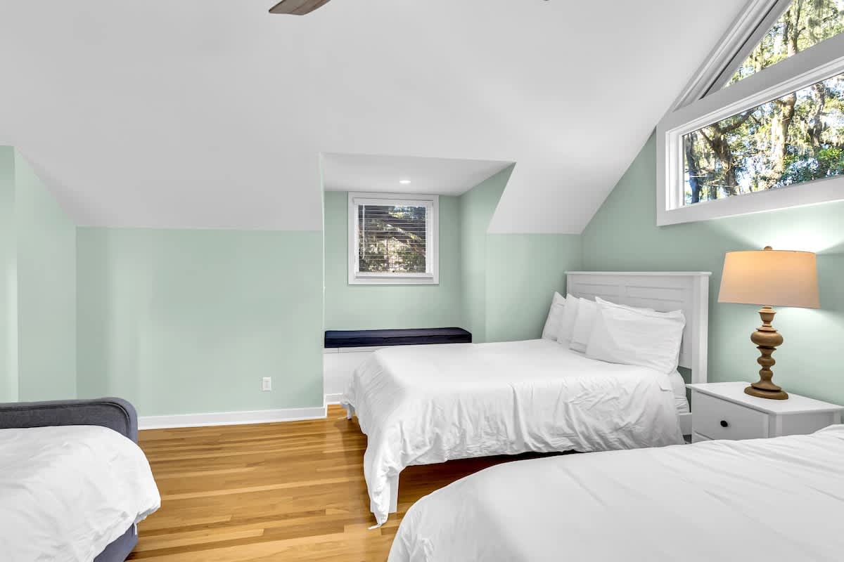 Drift off in this peaceful guest bedroom where soft mint walls and natural light create your perfect sanctuary for rest.