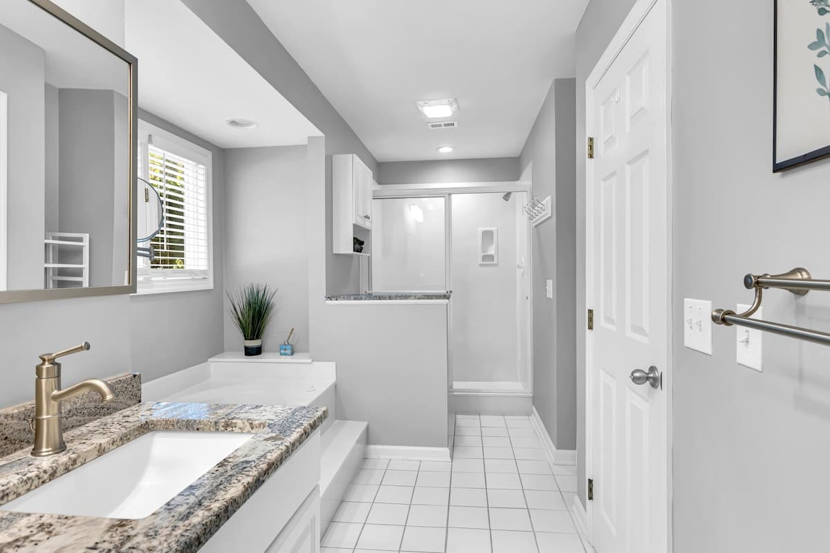 Step into your spacious bathroom featuring granite countertops, modern fixtures, and a refreshing glass-enclosed shower for your comfort.