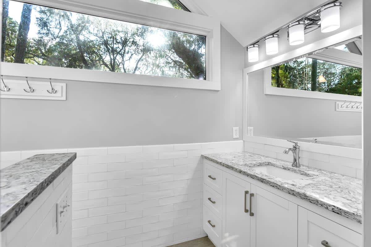 Refresh in your bright bathroom with marble counters and peaceful garden views through large windows.