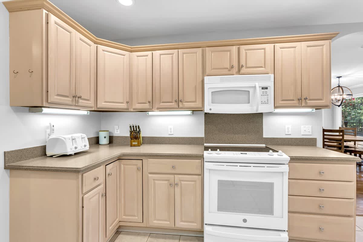 Your fully equipped kitchen features warm wood cabinetry, granite countertops, and modern appliances for comfortable home-away-from-home cooking.