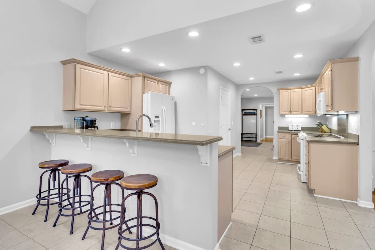 Your spacious kitchen invites culinary adventures with modern appliances and a breakfast bar where you can sip morning coffee.