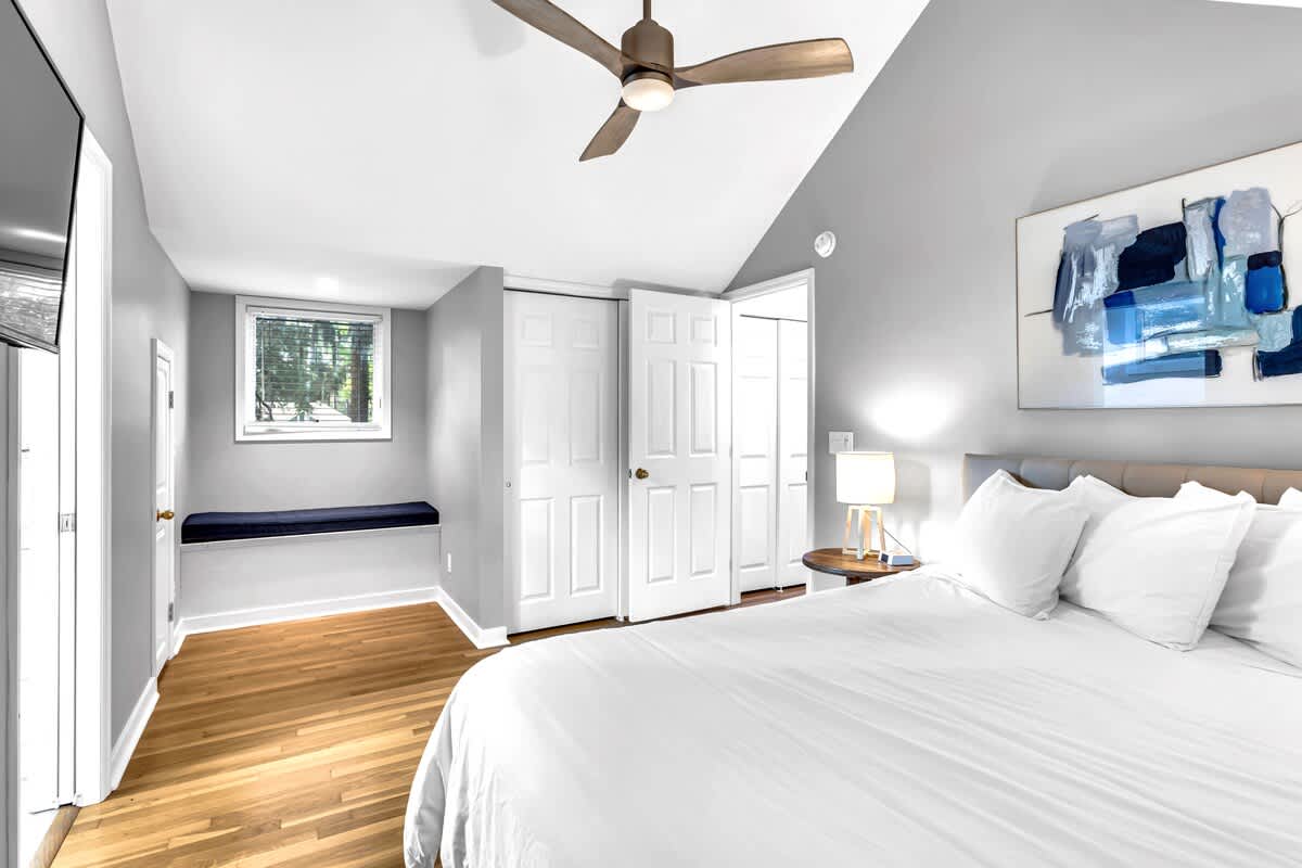 Unwind in your stylishly appointed bedroom featuring crisp linens, modern art, and a cozy window seat perfect for morning coffee.