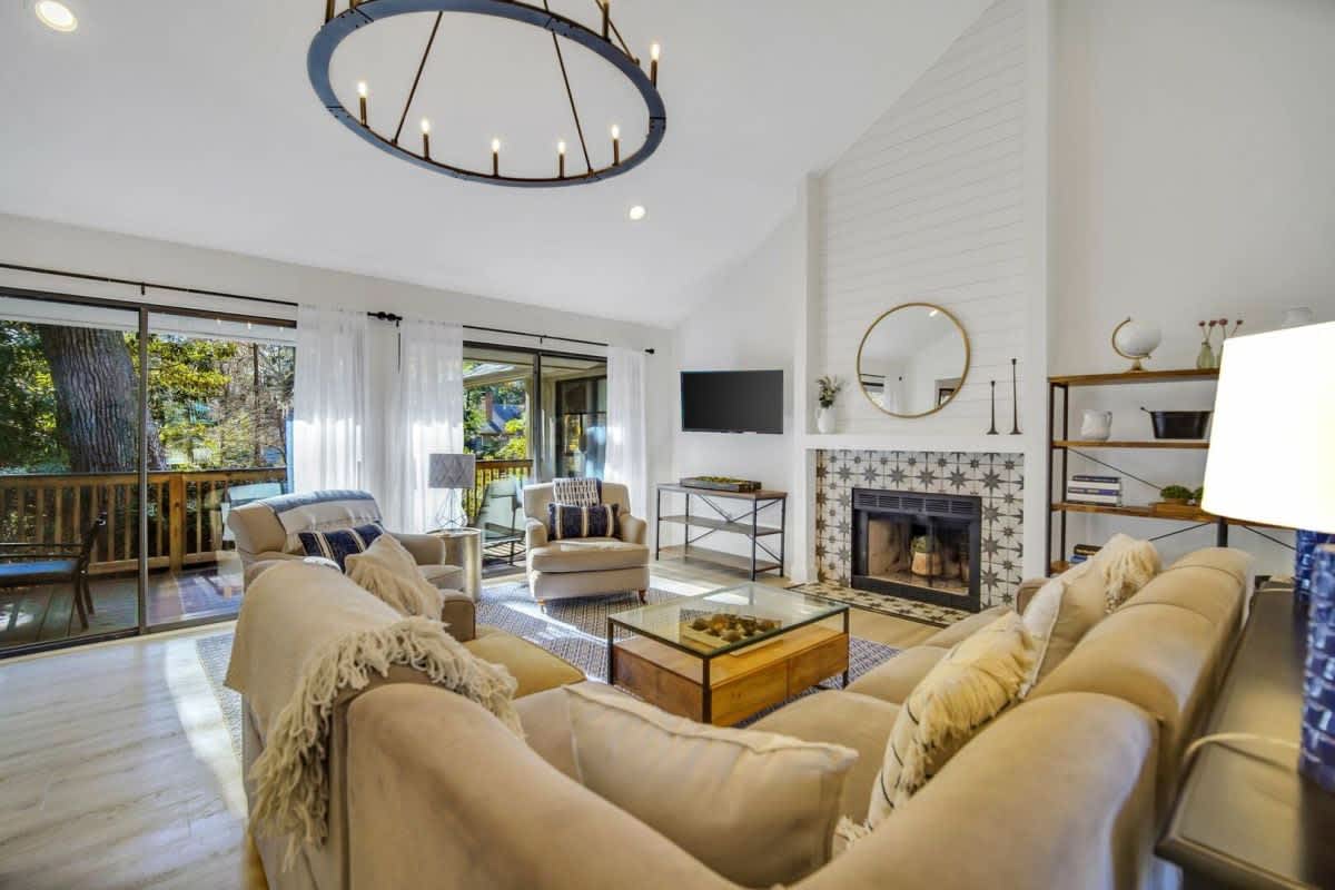 Relax in your bright, airy living room with soaring ceilings, cozy fireplace, and stunning chandelier creating the perfect atmosphere for unwinding.