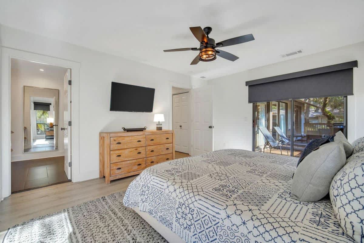Unwind in your stylish bedroom with ceiling fan, flat-screen TV, and private deck access for morning coffee.