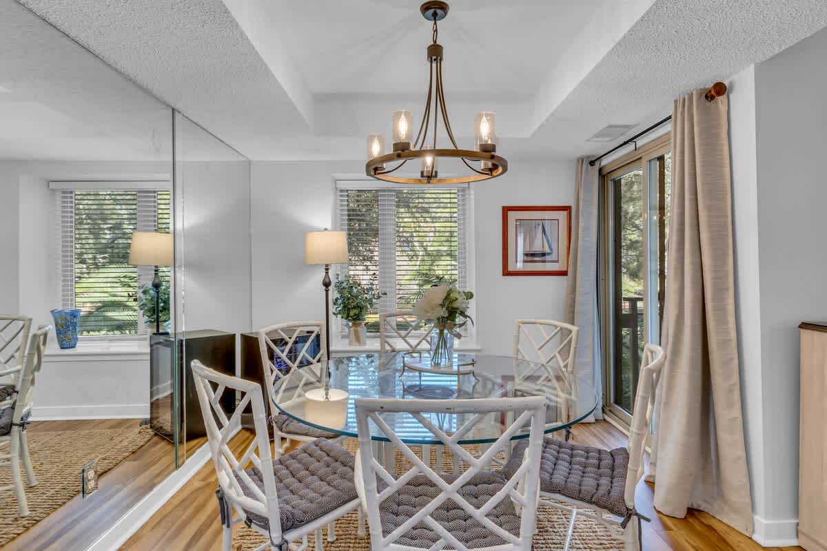 Gather around this elegant glass dining table where morning coffee and evening conversations flow naturally in your bright, airy space.