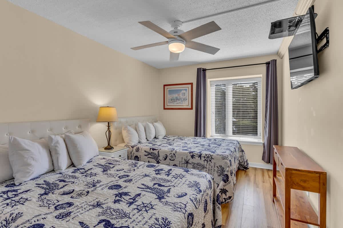 Drift off to sleep in your cozy twin bedroom, where nautical-themed bedding and gentle ceiling fan breezes create the perfect coastal retreat.