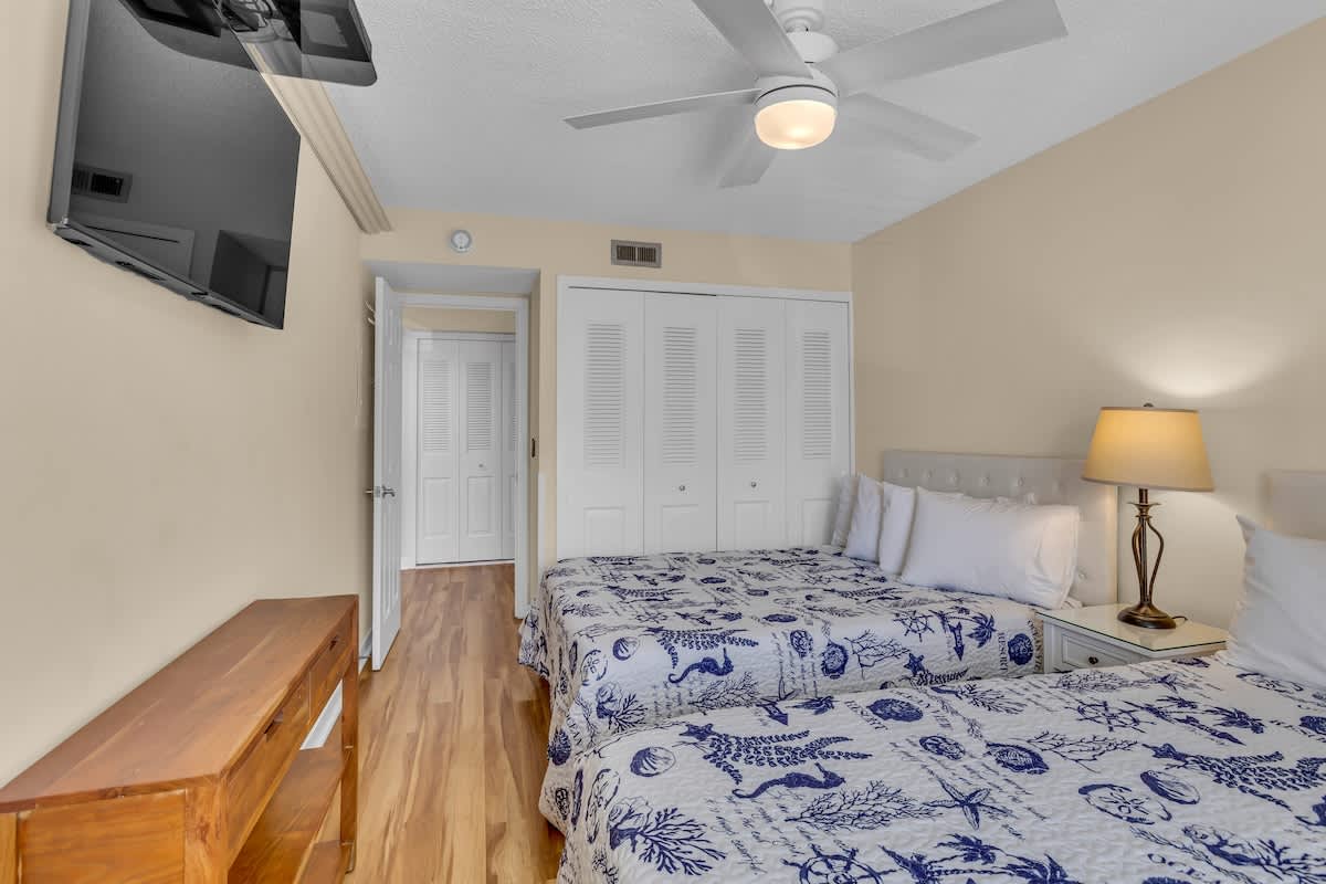 Relax in your bright bedroom with twin beds, soft linens, and coastal charm that promises restful nights.