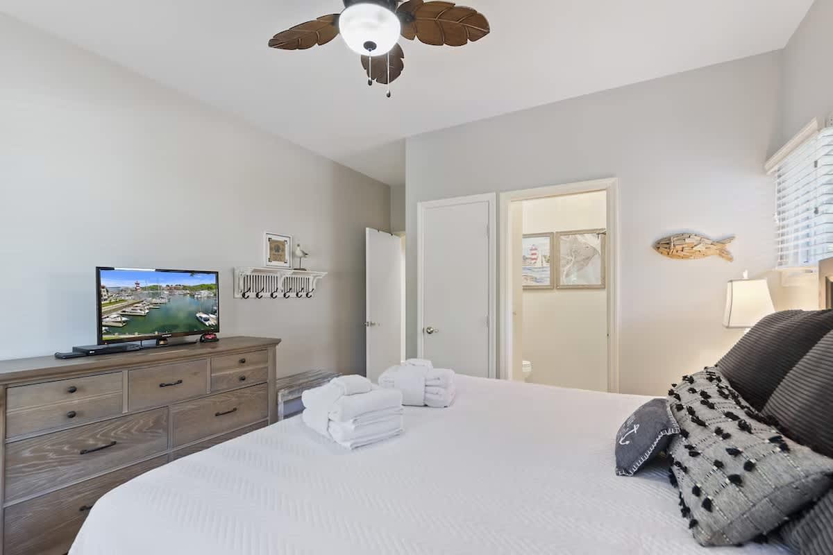 Unwind in your serene bedroom with plush linens, coastal decor, and entertainment at your fingertips.