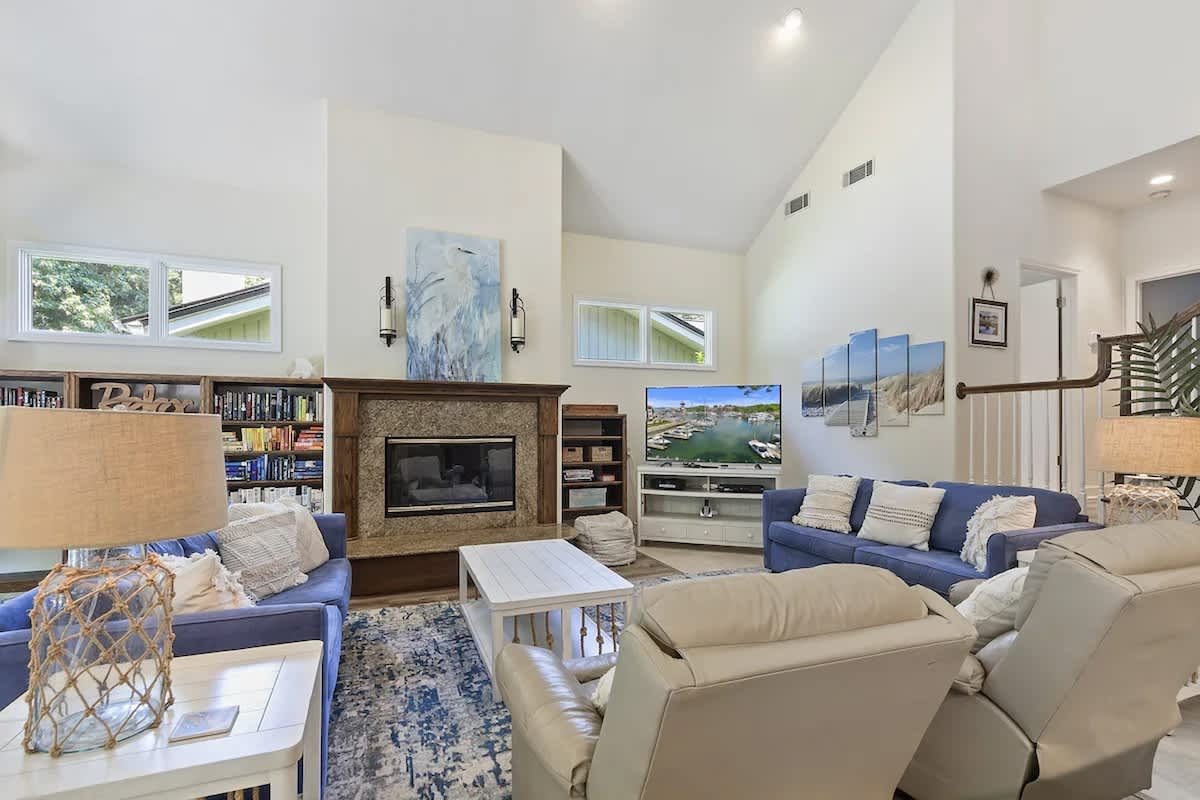 Sink into plush seating by the fireplace, browse books from the built-in shelves, and enjoy cozy evenings in this bright, airy living space.