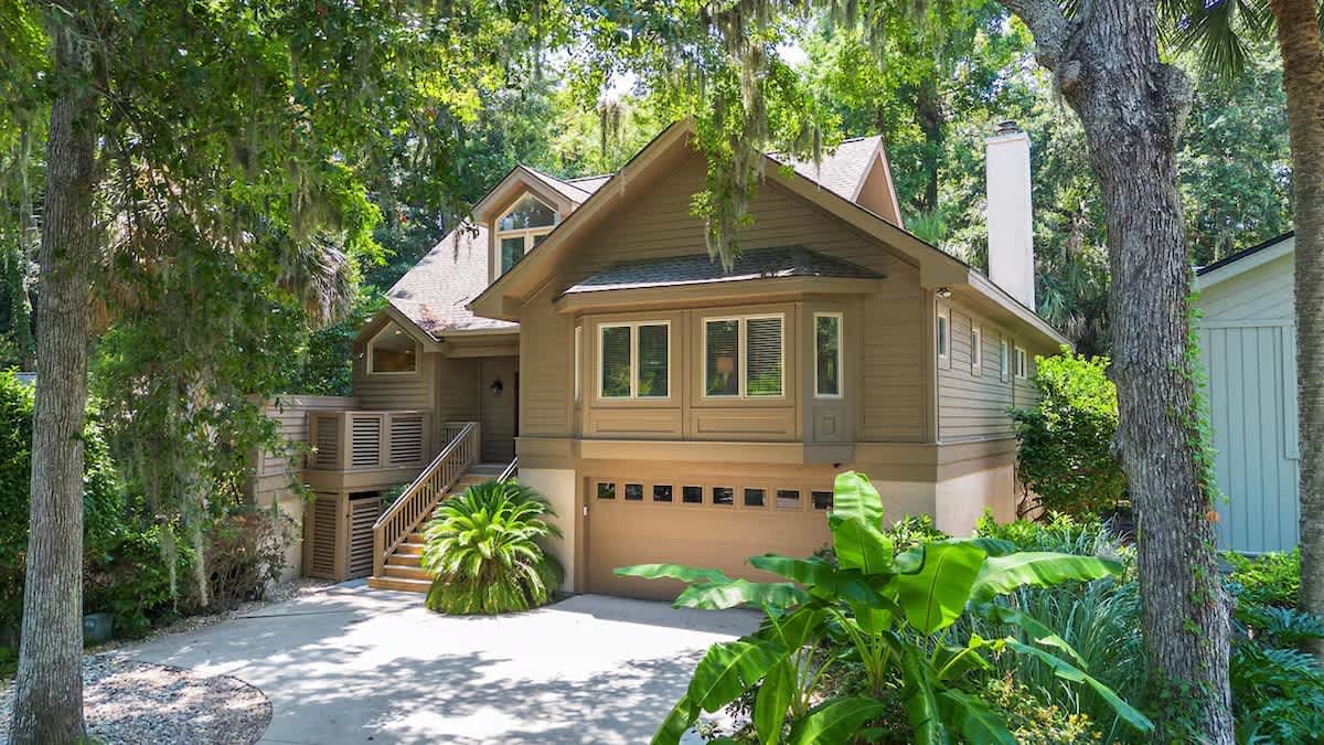 Charming forest retreat nestled among towering trees with tropical landscaping and peaceful setting.