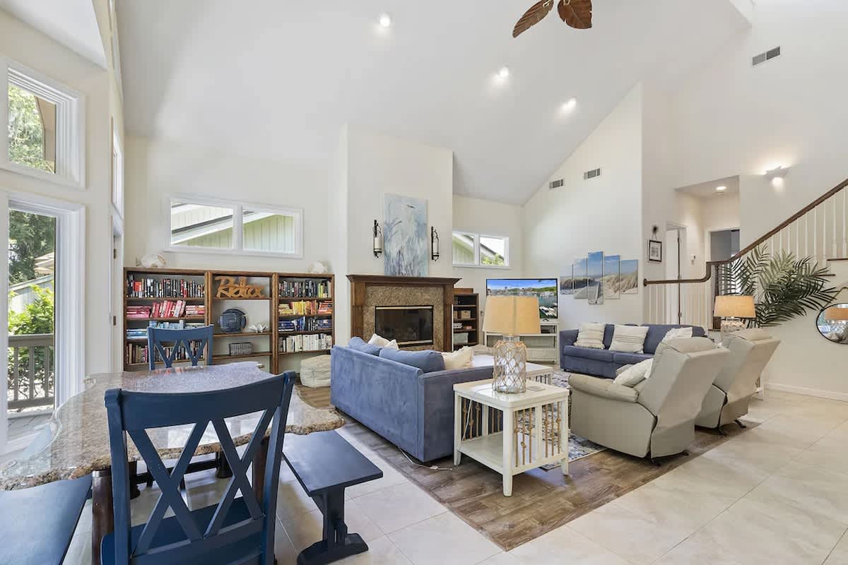 Relax in your spacious living room with soaring ceilings, cozy fireplace, and abundant natural light streaming through large windows.