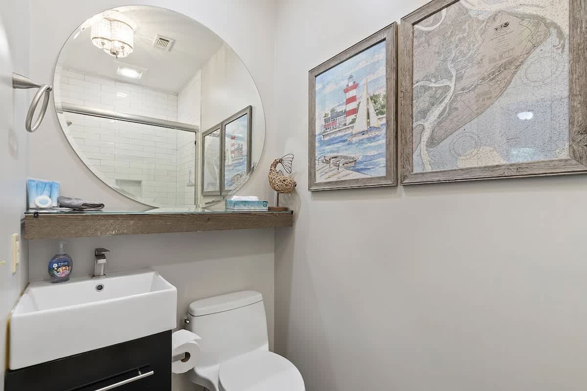 Your charming coastal bathroom features beautiful nautical artwork and modern amenities for a refreshing start to each day.
