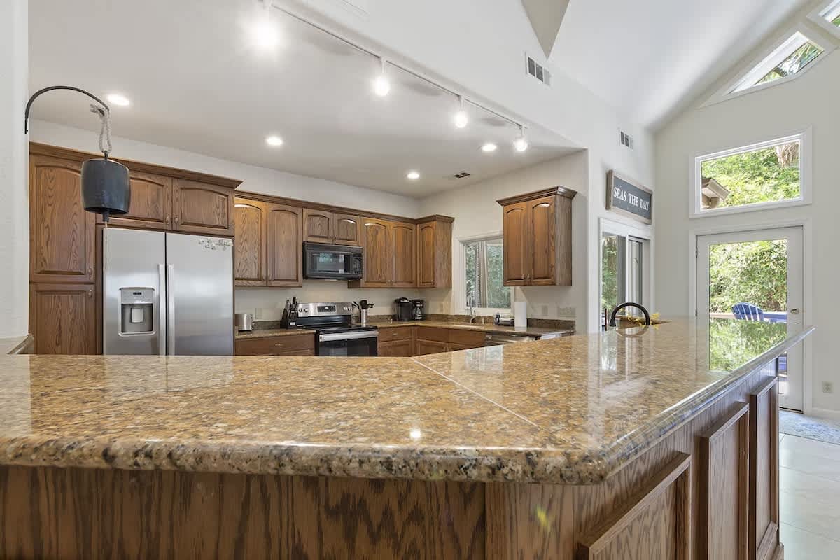 Your spacious kitchen awaits with granite countertops, premium appliances, and abundant natural light streaming through windows.