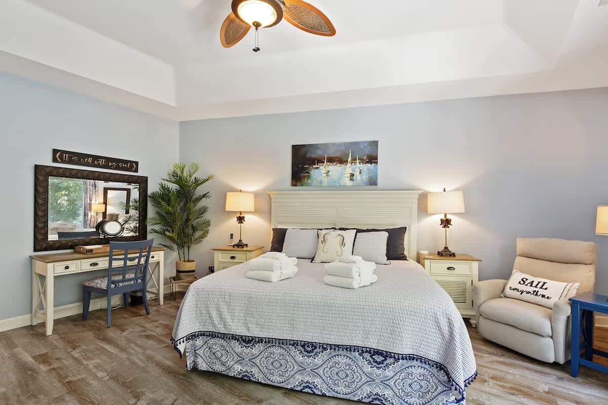 Unwind in your serene bedroom where coastal blues meet crisp whites, complete with a cozy reading nook and workspace for ultimate comfort.