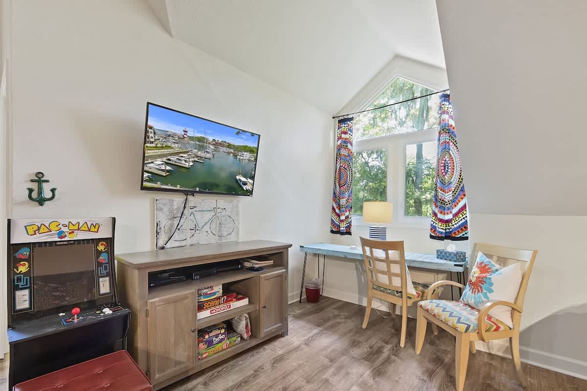 Your cozy retreat features a vintage arcade game, modern TV, and bright dining nook where memories are made.