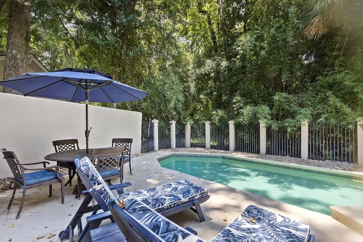 Dive into your private pool oasis, where tropical blue loungers and umbrella shade create your perfect poolside retreat.