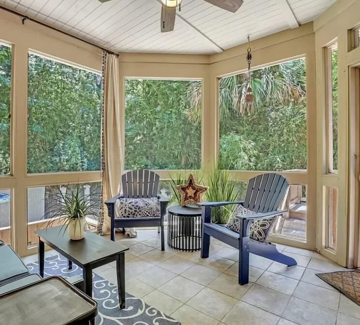 Relax in your private screened porch surrounded by lush tropical greenery, complete with comfortable seating and peaceful garden views.