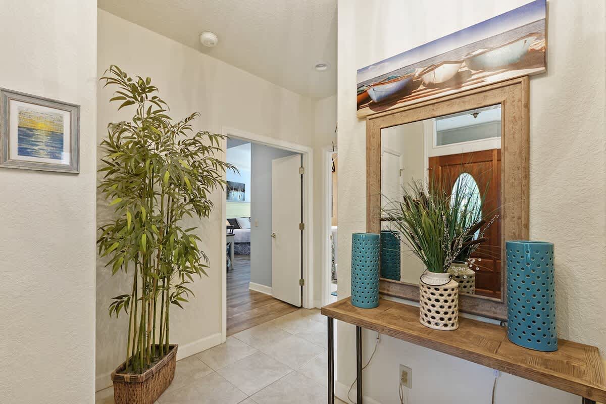 Step into your stylish coastal entryway where warm wood accents and tropical touches create an instant sense of relaxation and welcome.