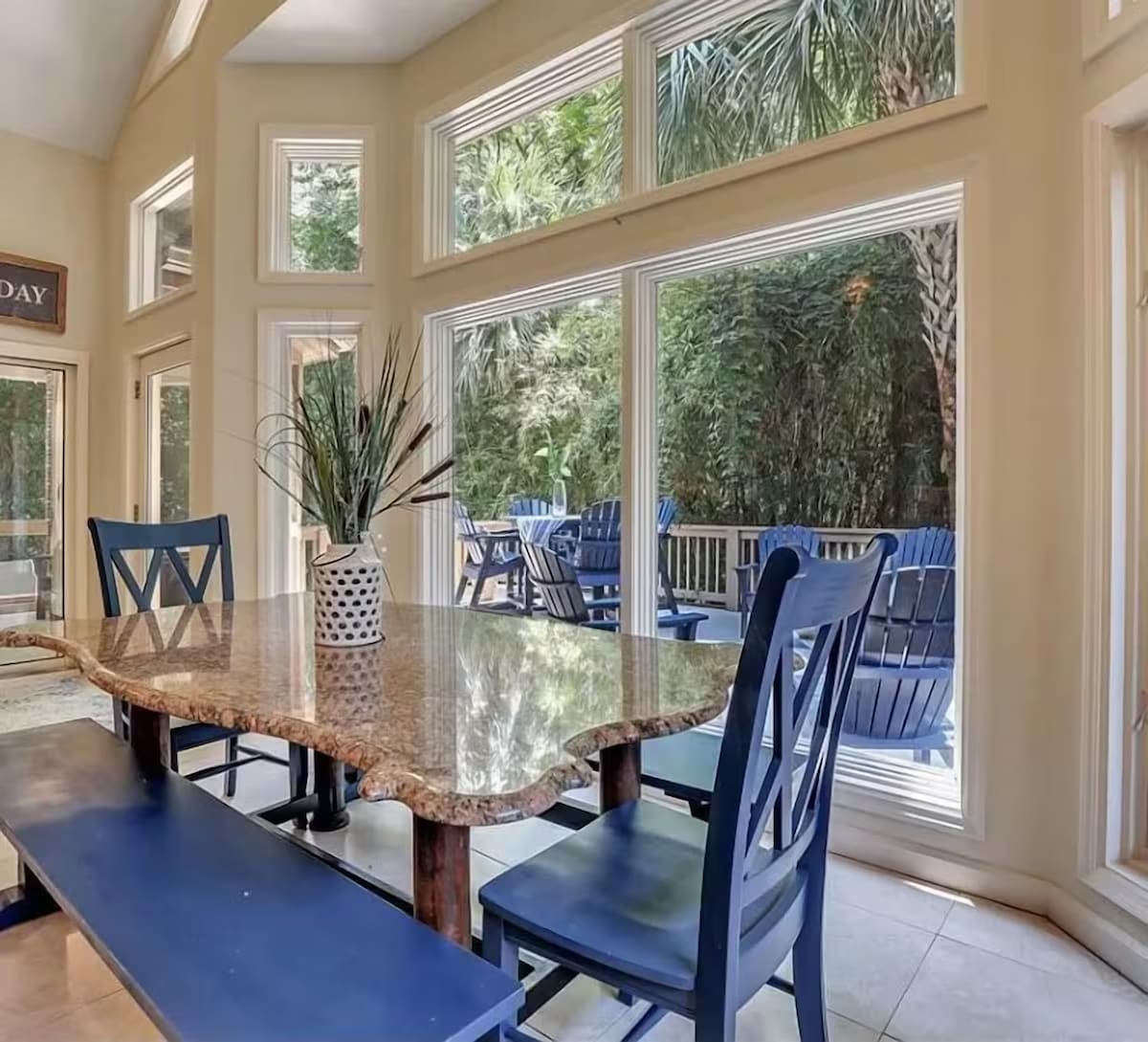 Gather around this elegant granite table where morning coffee tastes better with garden views streaming through floor-to-ceiling windows.
