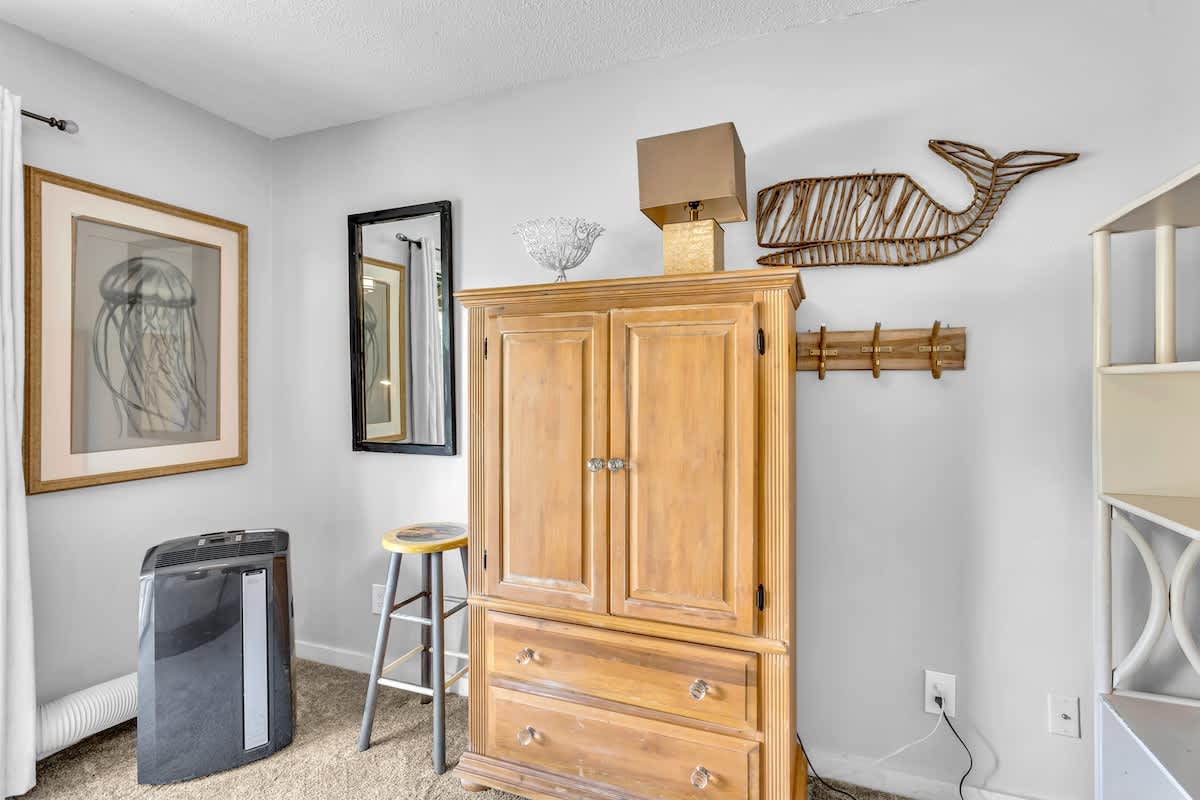 Your coastal-themed bedroom features a charming wooden armoire for all your belongings, plus thoughtful touches like whale art.