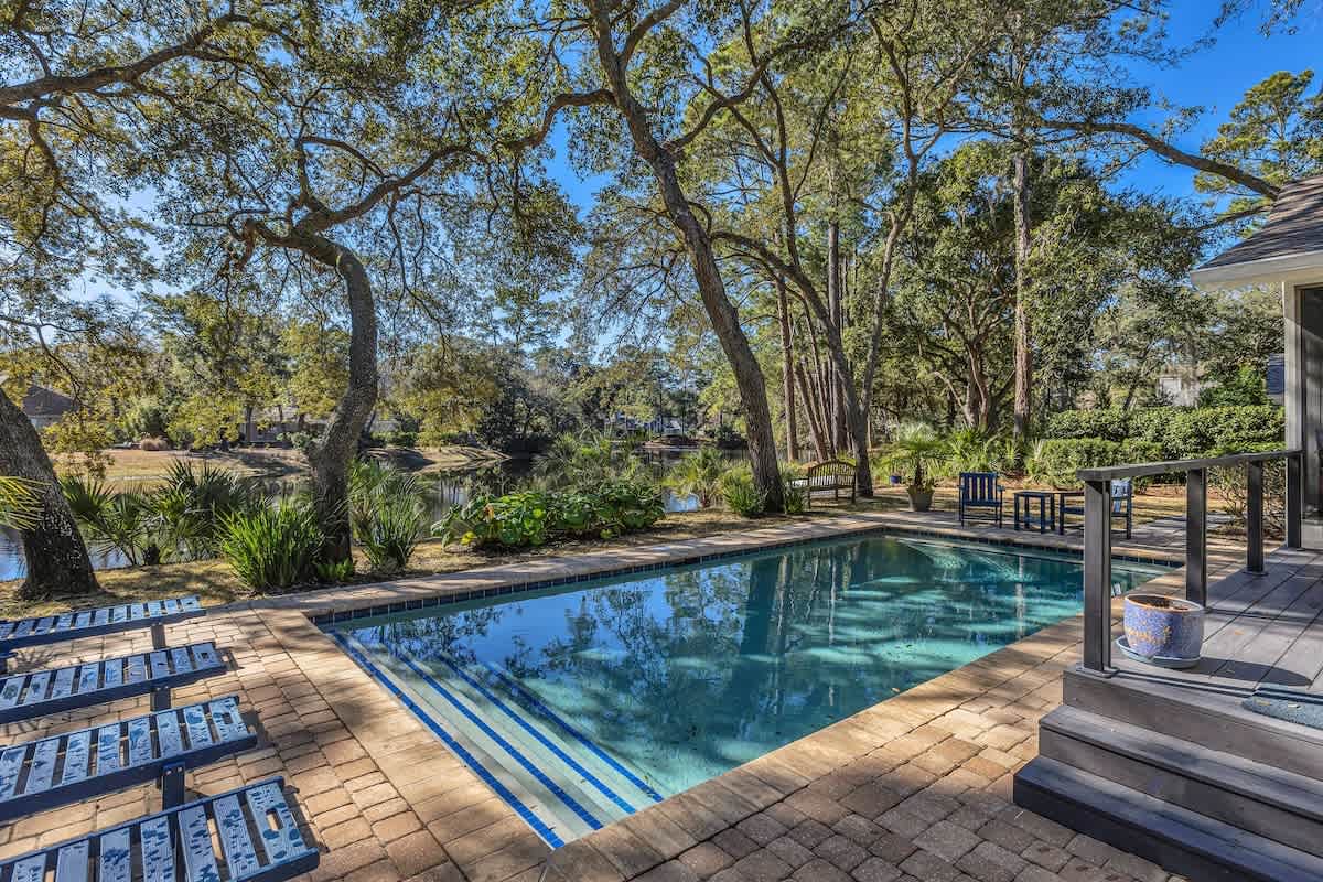Sparkling pool nestled among towering oaks creates your private outdoor sanctuary for relaxation and recreation.