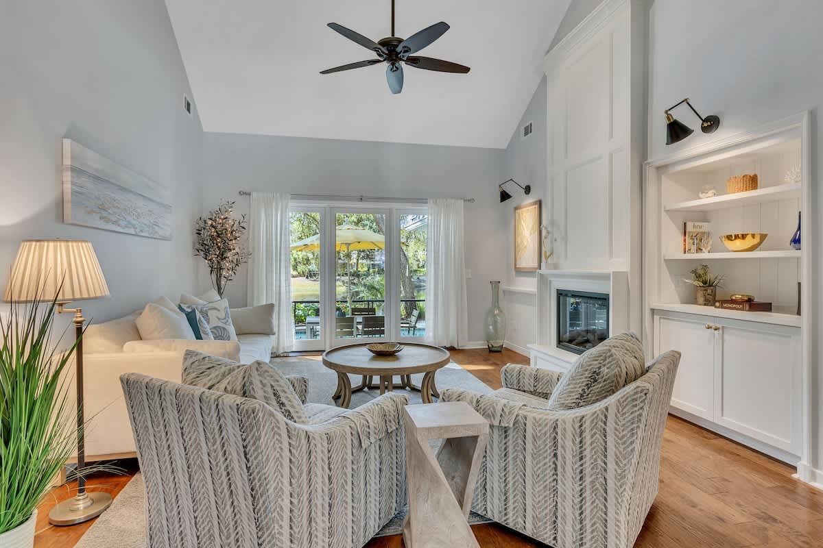 Sink into plush seating by your cozy fireplace, where coastal blues and thoughtful lighting create the perfect atmosphere for relaxing evenings.