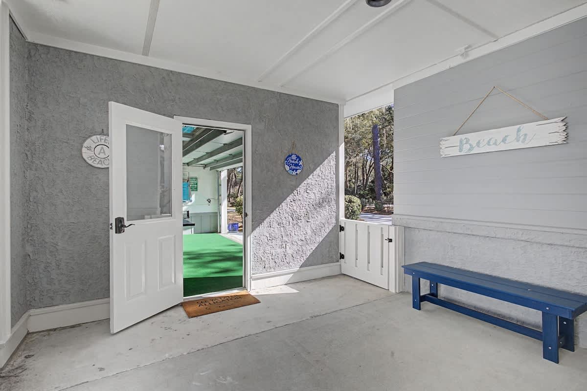 A covered breezeway connects the home to the garage turned game room