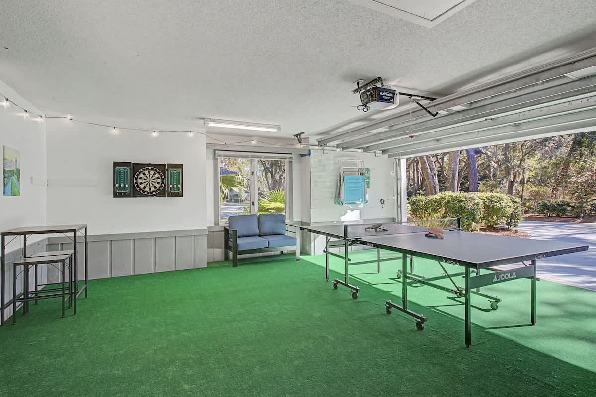 The garage has been converted into a game room with ping pong, darts and TV