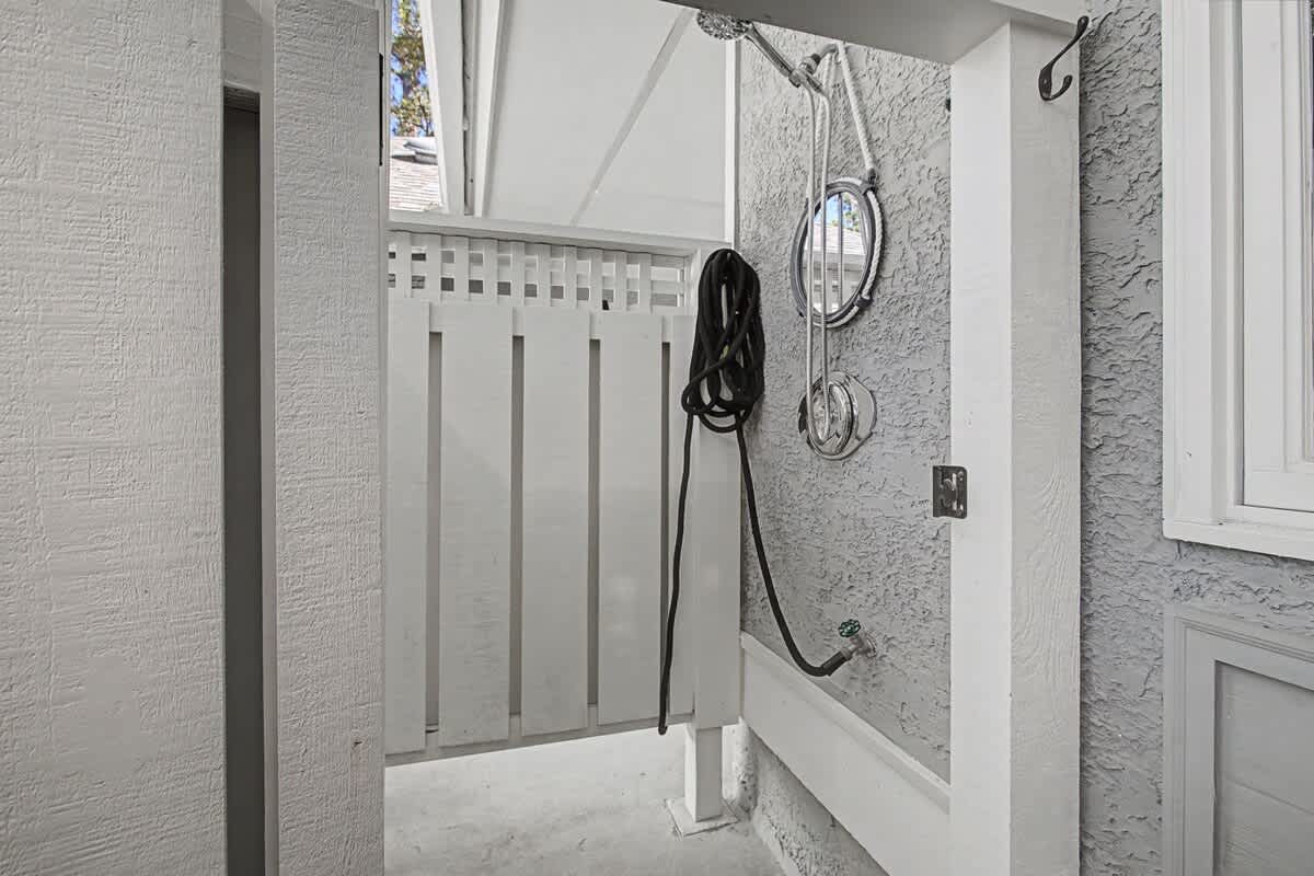 Step into your private outdoor shower space, where you'll enjoy refreshing rinses surrounded by clean white walls and natural light.