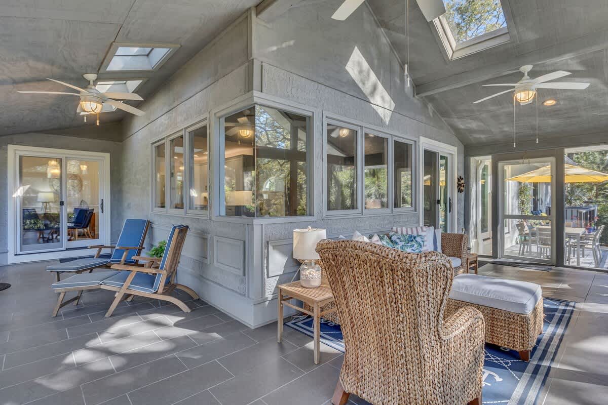 Relax in your light-filled sunroom where cozy wicker seating and skylights create the perfect retreat for morning coffee or evening conversations.