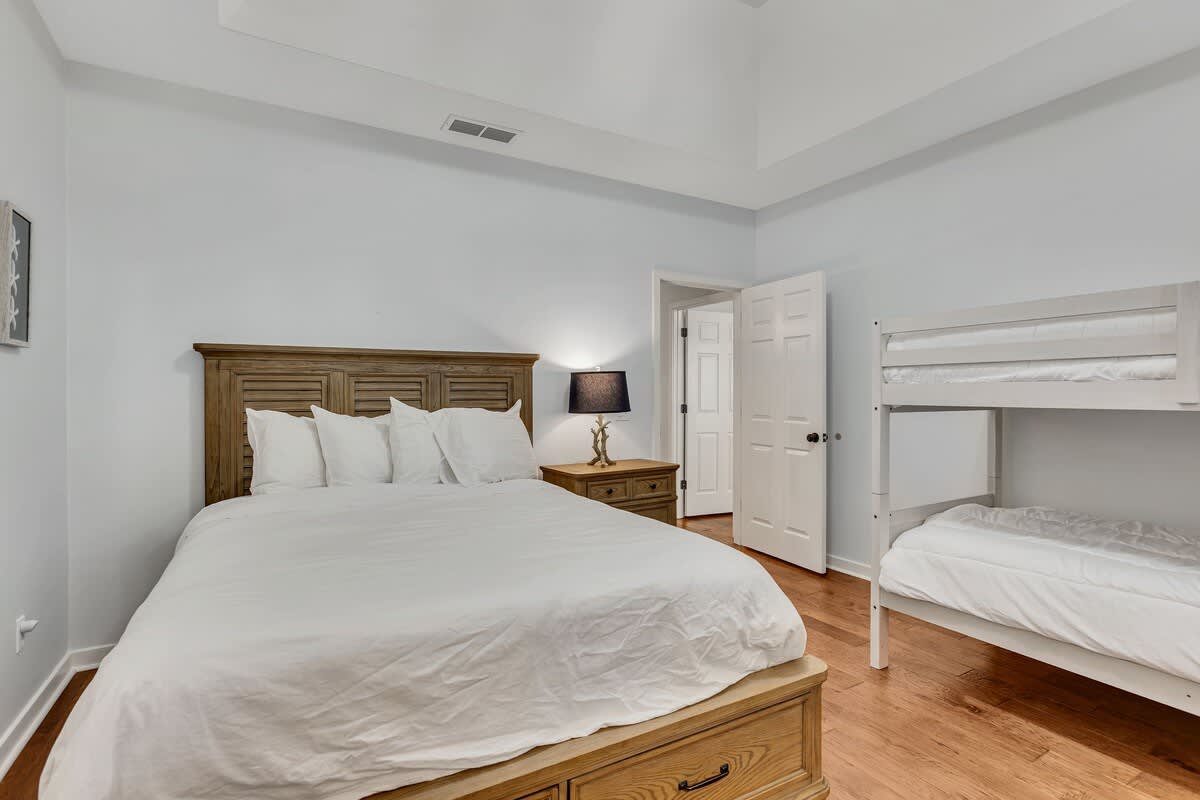 Slip into crisp white linens in your spacious bedroom, where warm wood floors and cozy furnishings create the perfect retreat.