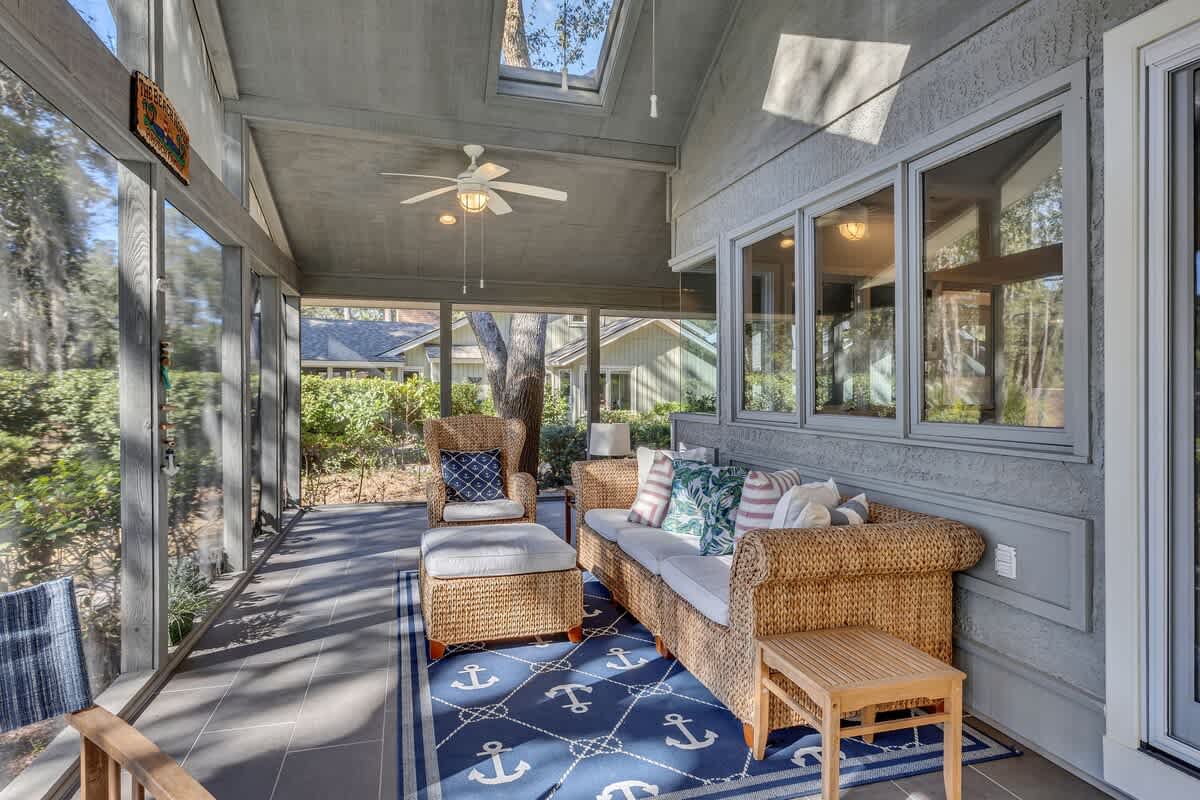 Relax in your screened porch with wicker seating, where natural light streams through skylights and gentle breezes flow through open windows.