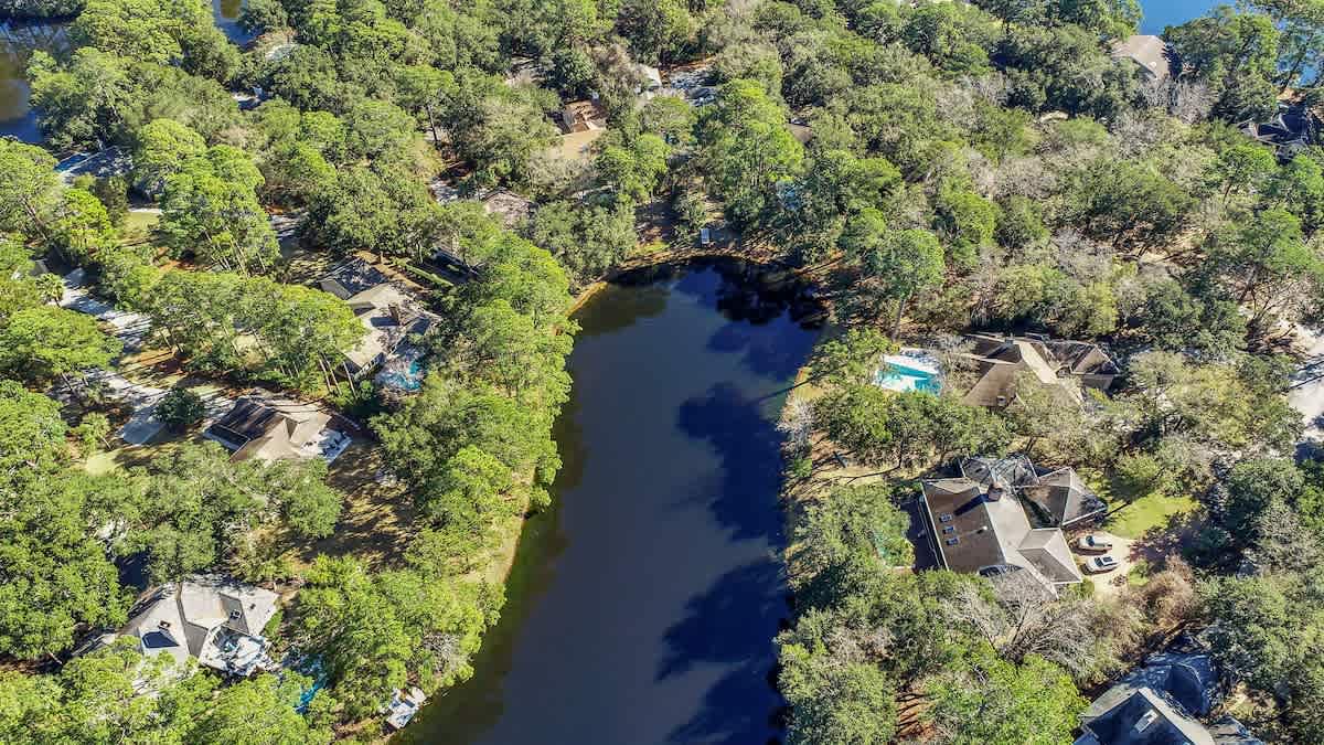 Stunning lakefront community nestled among mature trees with peaceful water views and private pools throughout the wooded neighborhood.